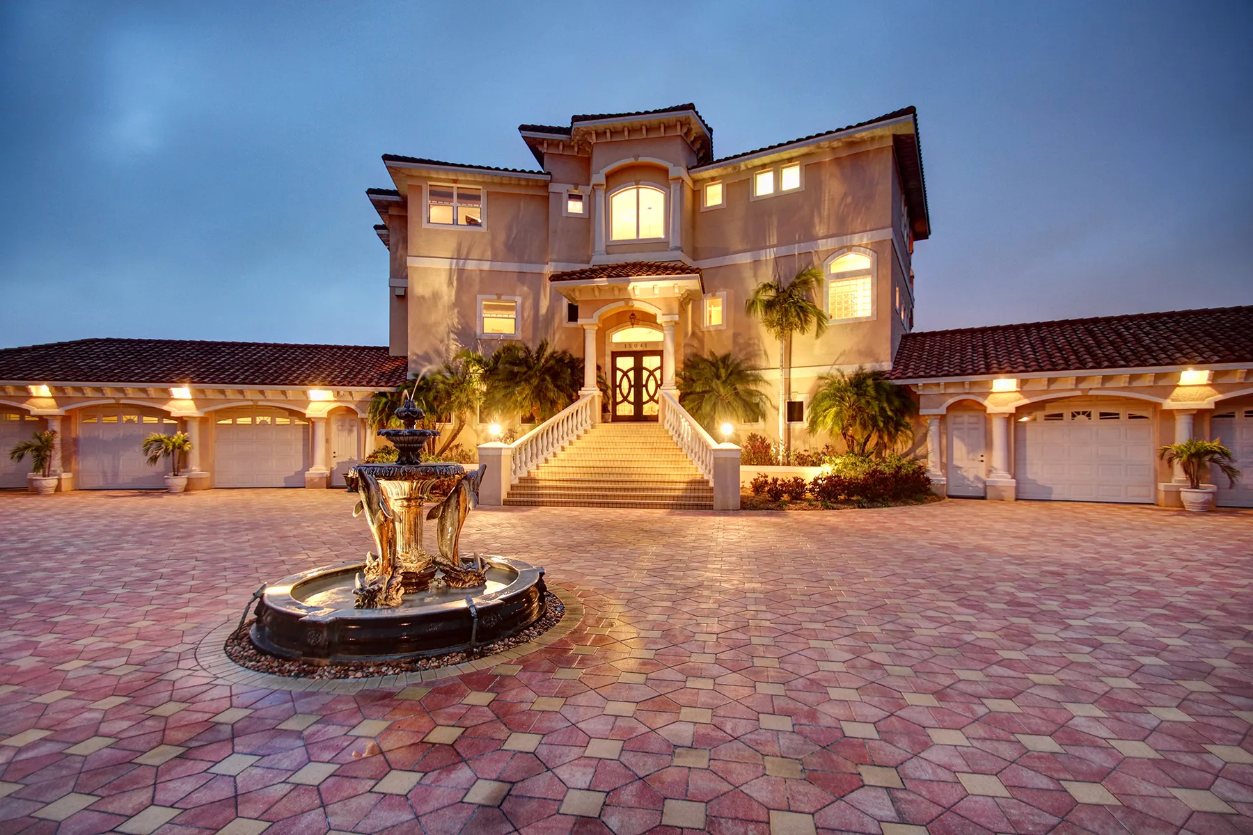 A home and courtyard illuminated at dusk